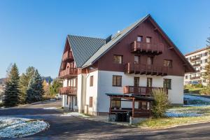 een groot huis met een schilddak bij Apartmán Krakonoš in Rokytnice nad Jizerou +7 foto's