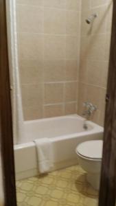 a bathroom with a white tub and a toilet at Star Inn Biloxi in Biloxi