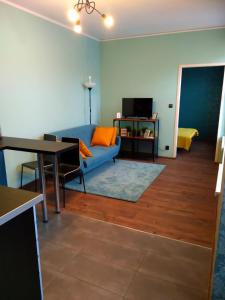 uma sala de estar com um sofá azul e uma mesa em Apartament Santo Bartolomeo em Toruń