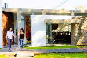 dos mujeres caminando delante de una casa en Casa Vida, en Santa Cruz de la Sierra