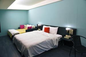 1 dormitorio con 2 camas y escritorio con silla en Tian Fang Ye Tan Hotel, en Yilan City