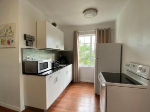 a kitchen with a white refrigerator and a microwave at Harding Boutique Apartments in Miami Beach