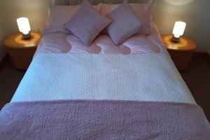 a large bed with two candles on two tables at Leafield Holiday Home in Stranraer