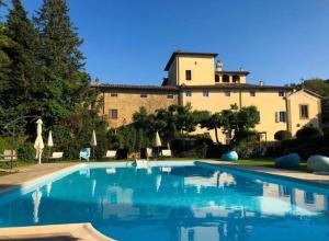 a large swimming pool in front of a building at Villa I Bossi in Arezzo