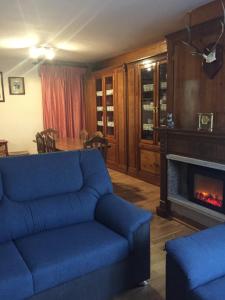 sala de estar con sofá azul y chimenea en Çò dera Piusa, en Vielha