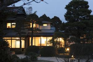 una casa iluminada por la noche con luces en Futsukaichi Hot Spring - Daimaru Besso en Chikushino