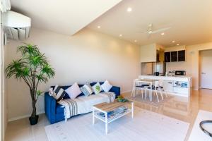 a living room with a blue couch and a table at Ocean Resort Maeda / Vacation STAY 3223 in Onna