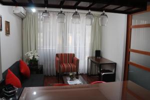 Austral Rentahome Santa Beatriz في سانتياغو: غرفة معيشة مع أريكة وكرسي