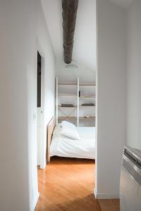 a bedroom with a white bed and a wooden floor at La mansarda sui Navigli in Milan