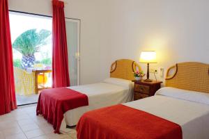 a hotel room with two beds and a window at Villa Acebuche in Cala d´Or