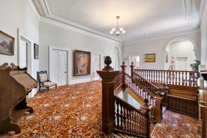 an ornate staircase in a home with a stair case at Empire Hotel Queenstown in Queenstown