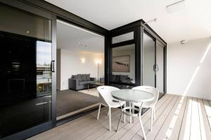 マウント・マウンガヌイにあるCentral Mount Apartment, Quiet and Spacious with Poolのテーブルと白い椅子のあるダイニングルーム +6枚の写真