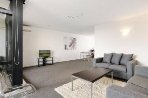 マウント・マウンガヌイにあるCentral Mount Apartment, Quiet and Spacious with Poolのソファとテーブルのあるリビングルーム