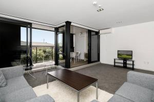 マウント・マウンガヌイにあるCentral Mount Apartment, Quiet and Spacious with Poolのソファとテーブルのあるリビングルーム