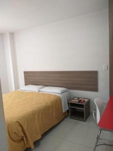 1 dormitorio con 1 cama grande y 1 silla roja en A Bogota On Holidays by Open - HOTEL, en Bogotá