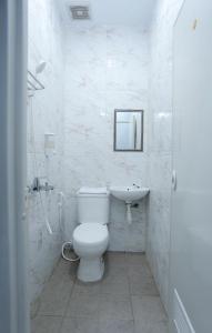 bagno bianco con servizi igienici e lavandino di ratana cengkareng syariah a Giacarta