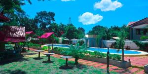 een resort met een zwembad en tafels en bomen bij Michelle Pension in Puerto Princesa City