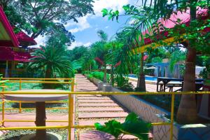 a view of a garden with trees and a yellow railing at Michelle Pension in Puerto Princesa City