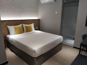 a bedroom with a large bed with yellow pillows at Hotel 99 Seri Kembangan Serdang in Seri Kembangan