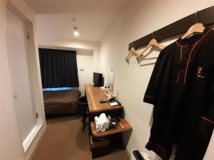 a room with a bedroom with a desk and a bed at HOTEL WIN in Imari