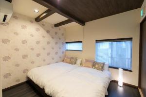 een slaapkamer met een groot bed en een raam bij CASA GRApP Nishikujyo in Osaka