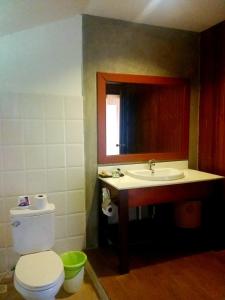 a bathroom with a toilet a sink and a mirror at Thanya Beach Resort - SHA Plus in Ko Ngai