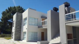 Un gran edificio blanco con escaleras al frente. en DOS PINOS, en Monte Hermoso