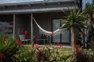 una casa con una hamaca delante en Cabin studio Cerca del mar - José Ignacio, en José Ignacio
