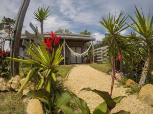 una casa con palmeras y un camino de grava en Cabin studio Cerca del mar - José Ignacio, en José Ignacio