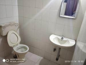 y baño con aseo y lavamanos. en UNNIKRISHNA LODGE, en Kochi