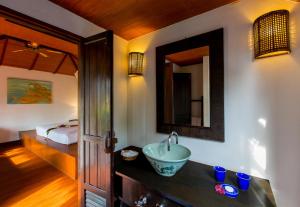 a bathroom with a sink and a bed at Elixir Koh Yao Yai - SHA Plus in Ko Yao Yai