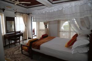 a bedroom with a bed and a desk and a window at Beytul Habaib in Lamu