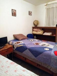1 dormitorio con 2 camas y escritorio con ordenador portátil en Huéspedes de Gaby, en Ciudad de México
