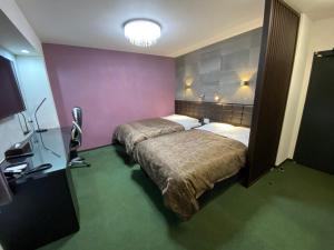 伊万里市HOTEL WIN的一间有两张床和一盏灯的酒店房间