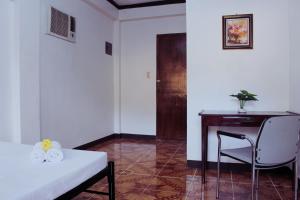 a room with a desk and a bed and a chair at Angel Gabriel Homestay in Coron