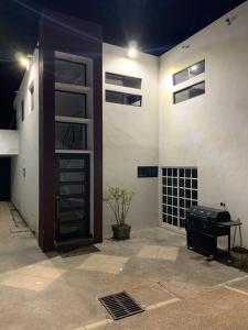 - un bâtiment blanc avec une porte et un grill dans l'établissement LOMAS SUITES, à Ciudad Valles