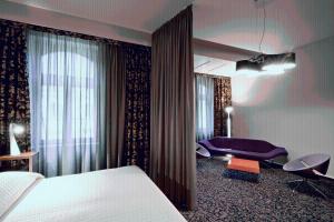 a hotel room with a bed and a purple chair at Hotel König von Ungarn in Vienna