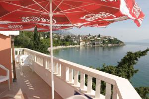 a balcony with an umbrella and a view of the water at Villa Nelo in Podaca