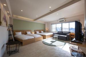 東京的住宿－STAY ARI Arakicho，客房设有两张床、一张沙发和一台电视。