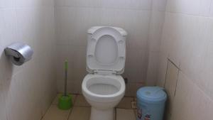 a small bathroom with a toilet and a trash can at Hotel Good News in Lira