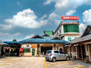 a car parked in a parking lot in front of a building at D' Anjung Inn in Tangkak