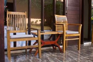 two chairs and a table and two chairs on a porch at Olas homestay bali in Uluwatu