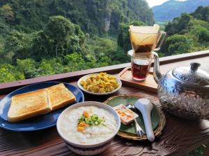a table with bowls of soup and bread and a cup of tea at ม่านฟ้า โฮมสเตย์ MaanFah Homestay in Ban Pha Mi