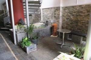 einen Innenhof mit einem Tisch, einer Bank und Pflanzen in der Unterkunft Central Hotel in Saint-Denis