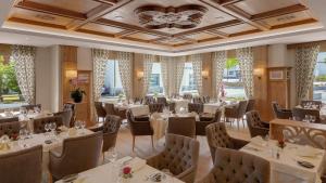 a restaurant with white tables and chairs and windows at Residenz Alte Post Bonaduz in Bonaduz