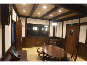 una sala da pranzo con tavolo e sedie in legno di Wakka a Minami Aso