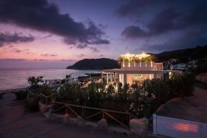 un edificio con vistas al océano por la noche en Baia Bianca Suites en Portoferraio