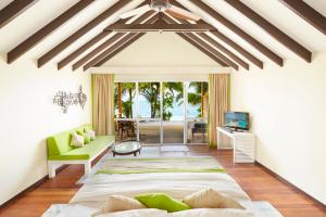 クレドゥにあるクレドゥ アイランド リゾート & スパのベッドルーム(大型ベッド1台付)、リビングルームが備わります。