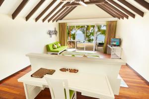 a living room with a table and a view of the ocean at Kuredu Island Resort & Spa in Kuredu