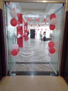 um corredor com balões vermelhos e brancos num quarto em Hotel the Ideal em Kushinagar